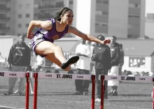 A woman jumping a hurdle